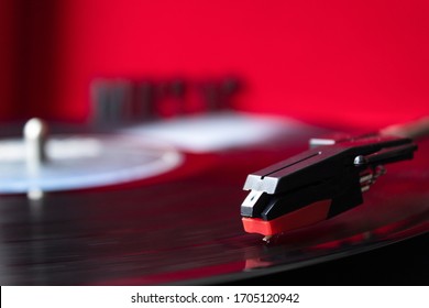 Close Up To A Turn Table Needle Playing A LP Vinyl Disc With Turn Table And Red Background. Music Lovers Concept