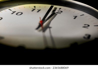 It's close to twelve, the clock is ticking. Modern white clock shows the time 5 before 12. Close up to a wall clock, with five minutes to twelve o'clock. Time running out to avoid the climate change - Powered by Shutterstock