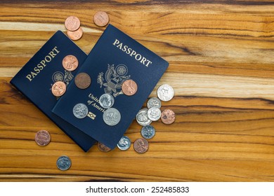 Close Up Of Two American Passports And Coins For A Cheap Travel Concept