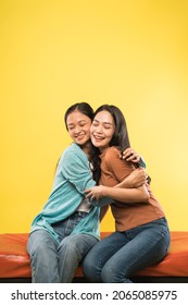 close up of two attractive women hugging while chatting sitting