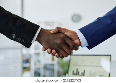Close up of two business people shaking hands after successful partnership negotiation in office
