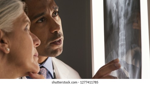 Close up of two doctors reviewing patients xray of spine - Powered by Shutterstock