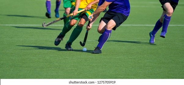 Close up of two field hockey players, challenging eachother for the control and posession of the ball during an intense, competitive match on professional level - Powered by Shutterstock