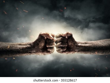 Close Up Of Two Fists Hitting Each Other Over Dramatic Sky Background