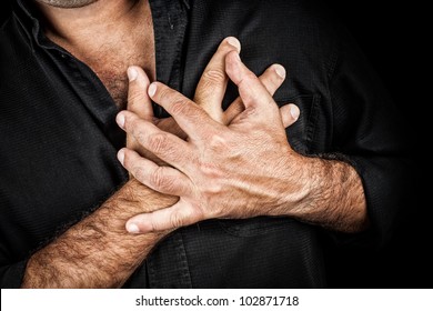 Close Up Of Two Hands Grabbing A Chest On A Black Background, Useful To Represent A Heart Attack Or Any Sentimental Concept