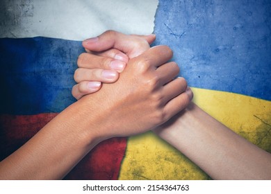 Close up of two hands people handshaking after ceasefire between Russia and Ukraine flag background