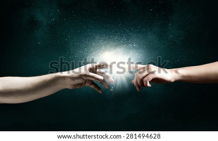 Close up of two hands reaching each other with fingers