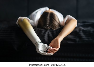 Close Up Two Hands Of Woman With Bionic Arm On Black Bed At Home, Person Lost Her Arm, Girl Artificial Prosthetic Limb