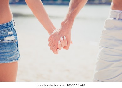 Close up of two happy young lovers holding hands
