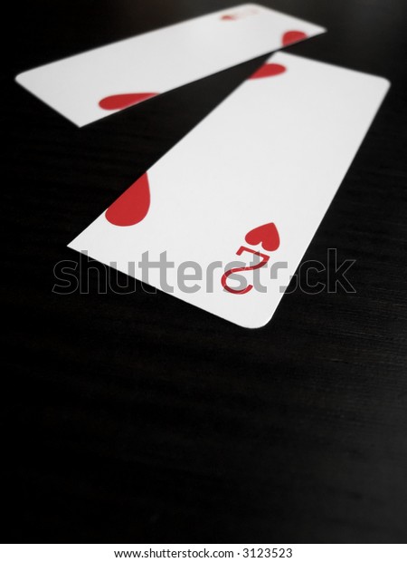 Close up of a two of hearts card split down the\
middle with shallow DOF