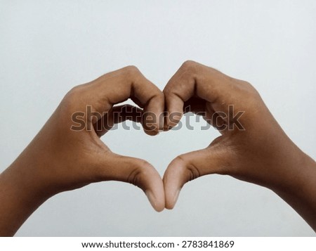 Close up of two human hands forming a heart shape symbol isolated on a white background