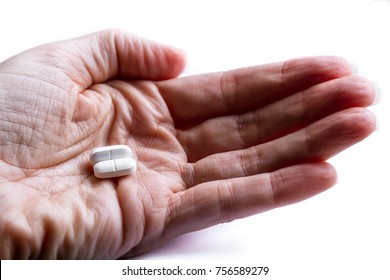 Close Up Of Two Opioid Tablets On A Hand