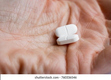 Close Up Of Two Opioid Tablets On A Hand