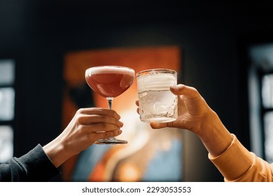 Close up of two people cheering cocktails in bar or disco club drinks and cocktails concept - Powered by Shutterstock
