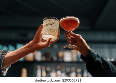 Close up of two people cheering cocktails in bar or disco club drinks and cocktails concept