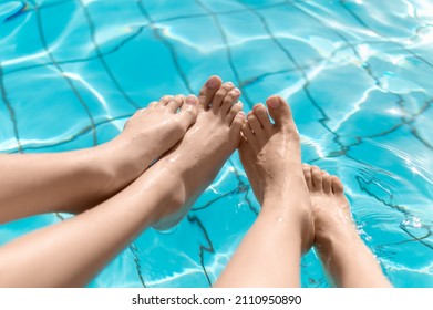 Close up of two people's legs by the pool side - Powered by Shutterstock