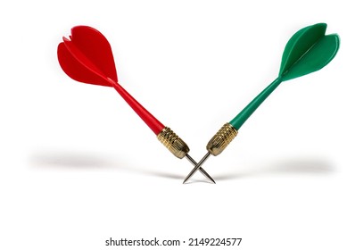 Close up of two plastic darts in red and green color crossed in the area of the tips with pointed metal tip on white background