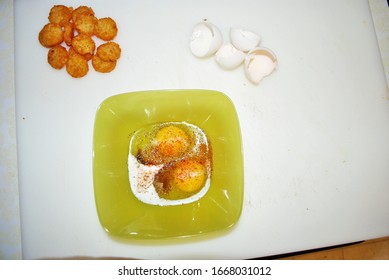 Close Up Of Two Raw Seasoned Eggs In A Green Plastic Bowl Hash Browns And Eggshells