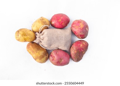 Close up of two red potatoes against white background, Above view of colorful fresh little potatoes spilling from burlap bag on a rustic,Raw red potatoes in burlap bag isolated on white background - Powered by Shutterstock