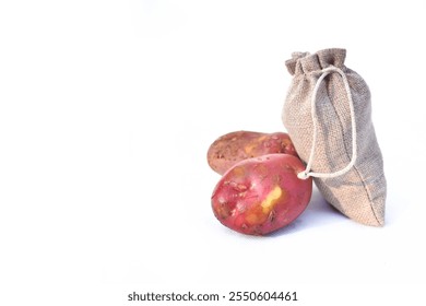 Close up of two red potatoes against white background, Above view of colorful fresh little potatoes spilling from burlap bag on a rustic,Raw red potatoes in burlap bag isolated on white background - Powered by Shutterstock