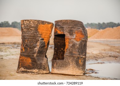 Close up of two rusted and brown colored broken oil drums at the beach