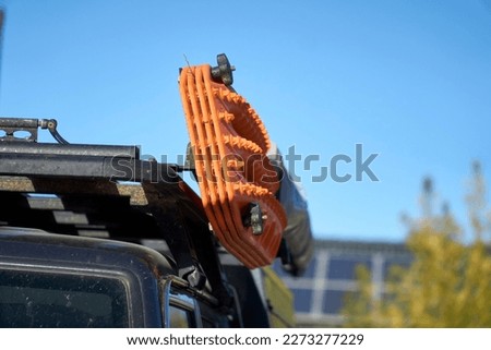 Close up of Two sets of Orange Recovery tracks, boards, ladders mounted on an angle not the roof rack on an off-road 4x4 for use on slippery surfaces like snow, mud or sand
 ストックフォト © 