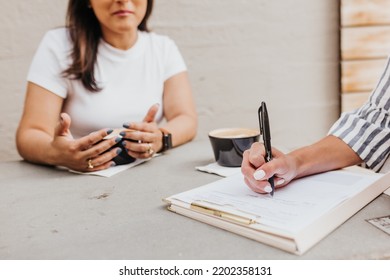 Close Up Of Two Women Having A Work Meeting Outside Coffee Shop