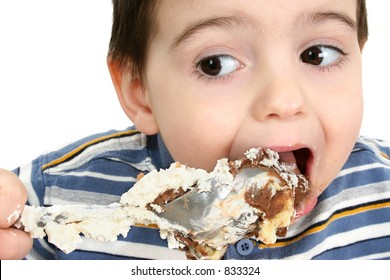  Close Up Of A Two Year Old Boy Eating Possum Pie With A Big Silver Spoon. Shot In Studio Over White.