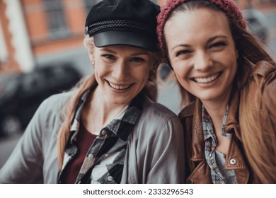 Close up of two young women taking a selfie while walking on the city street - Powered by Shutterstock