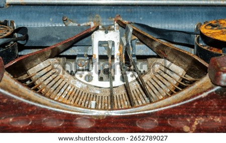 Close up of the typeface of an old rusty typewriter with some of the letters stuck in the up position