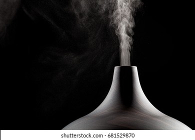 Close up of an ultrasonic aromatherapy oil diffuser in use. Atomized water droplets being dispensed into the air.
