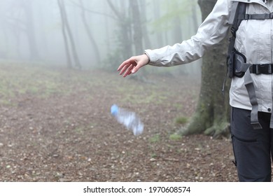 Close up of an uncivil trekker throwing garbage to the ground in nature