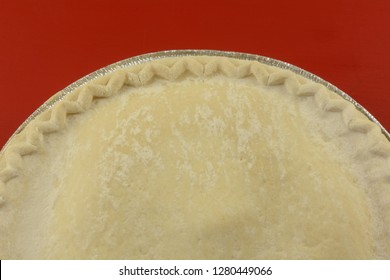 Close Up Of Uncooked Frozen Apple Pie On Red Background