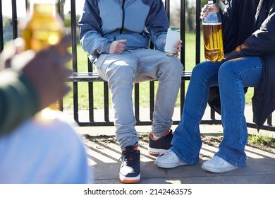 Close Up Of Underage Teenagers Drinking Alcohol In Park