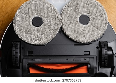 Close Up Underside of Robotic Mop Vacuum Cleaner Resembling a Minion or Smiley Face
