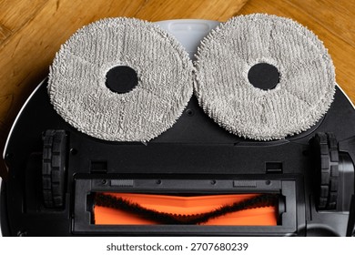 Close Up Underside of Robotic Mop Vacuum Cleaner Resembling a Minion or Smiley Face