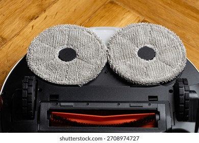 Close Up Underside of Robotic Mop Vacuum Cleaner Resembling a Minion or Smiley Face