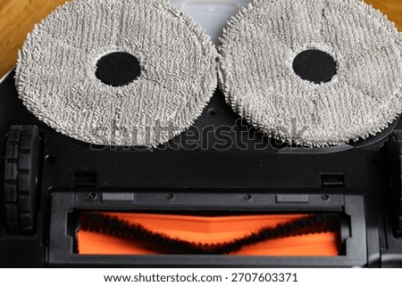 Close Up Underside of Robotic Mop Vacuum Cleaner Resembling a Minion or Smiley Face