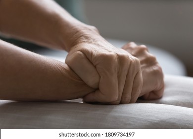 Close up unhappy depressed mature woman sitting on couch alone, feeling desperate and depressed, wrinkled female hands folded on laps, health or emotional problem concept, mental disorder - Shutterstock ID 1809734197