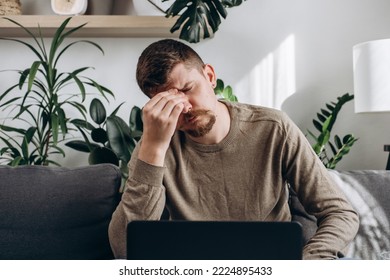 Close Up Of Unhappy Young Man Working On Laptop Massage Eyes Suffer From Blurred Vision Or Dizziness, Exhausted Caucasian Male Feel Unwell Having Headache Migraine And Overwork. Health Problem Concept