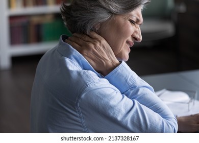 Close up unhealthy old 60s woman suffer from neckache, pinched nerves, massaging stiff sore neck or tensed muscles relieving painful feelings. Incorrect posture, fibromyalgia, chronic diseases concept