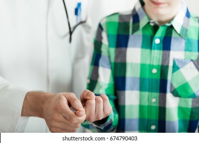 Close Up of Unidentifiable Male Doctor Pricking Finger of Young Teenage Boy, Drawing Blood for Diabetes Blood Test in Clinic Office