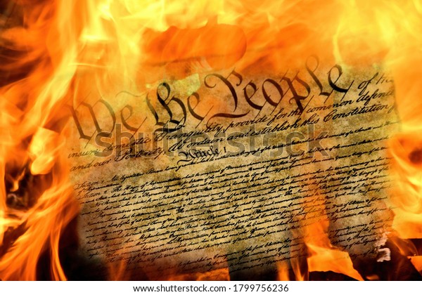 close up of United States constitution document\
burning in flames