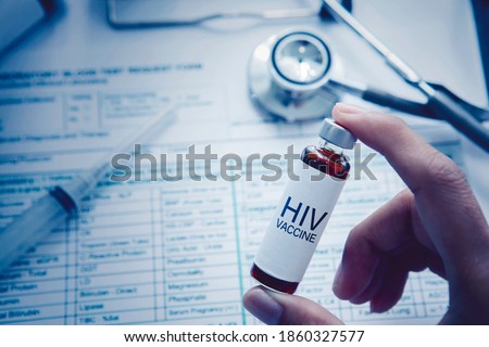 Close up of unknown female doctor hand holding an ampule with HIV vaccine text