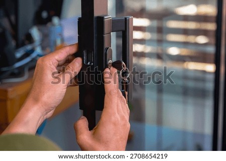 Close up unknown locksmith hands installing mirror door key in house during home improvement