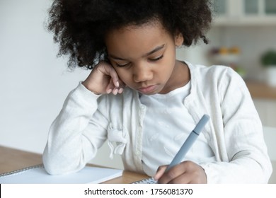 Close Up Unmotivated Small African Schoolgirl Sit At Table Hold Pen Noting Feels Upset. Attention Disorder, Disinterested In Study, Learning Problem Need Tutor, Tired Child Due Lot Of Homework Concept