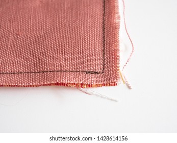 Close Up Of Unravel Pink-orange Linen Fabric Texture With Brown Thread Stitches With Copy Space. Materials, Textiles And Garment Concept.