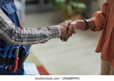 Close Up Of Unrecognizable African-American Woman Shaking Hands With Handyman Standing In Home Interior, Copy Space