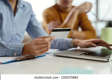Close up of unrecognizable businesswoman using credit card and laptop while buying on the internet.  - Shutterstock ID 1350370883
