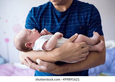 Close up of unrecognizable father holding his newborn baby son